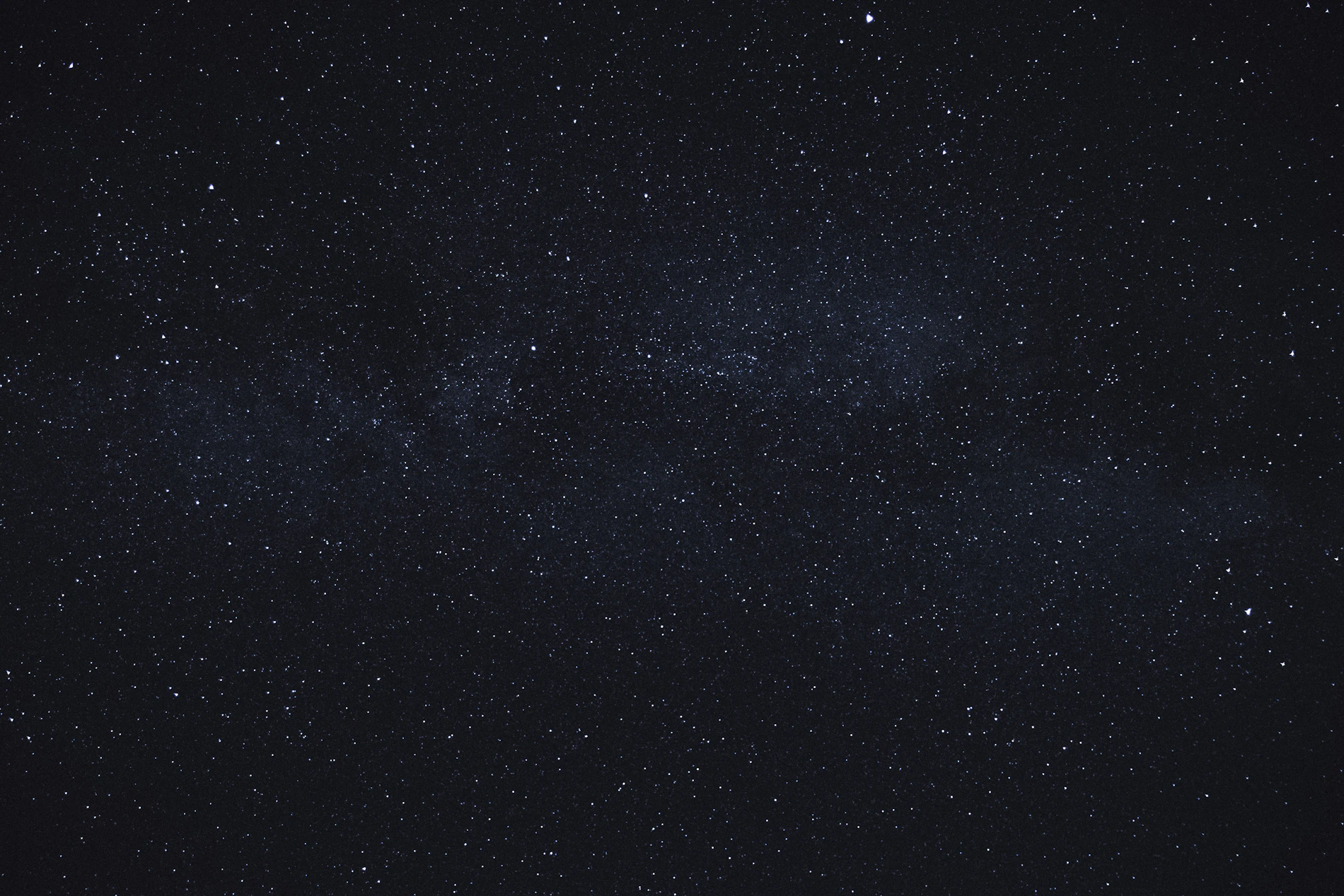 Céu noturno com a faixa da Via Láctea sobre o horizonte